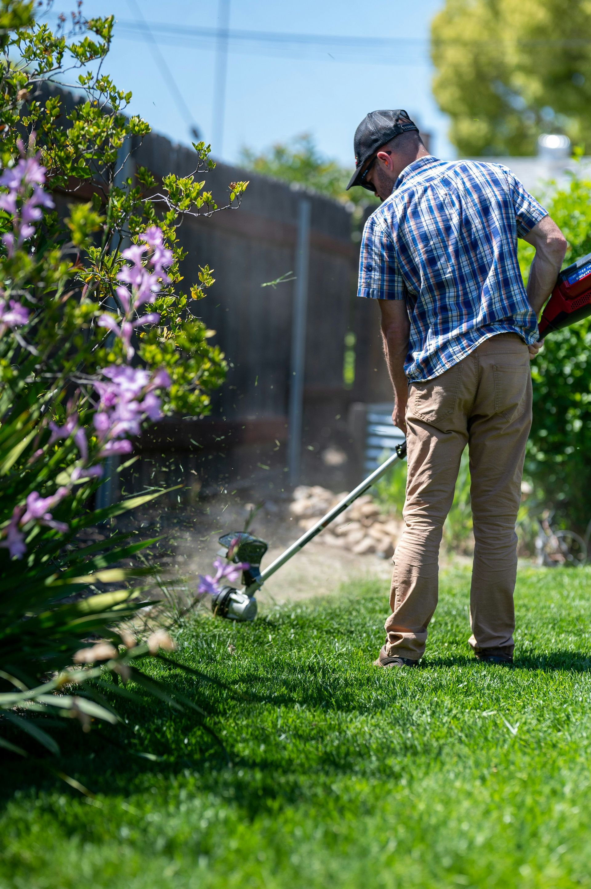 a man using a lawn mower to cut grass