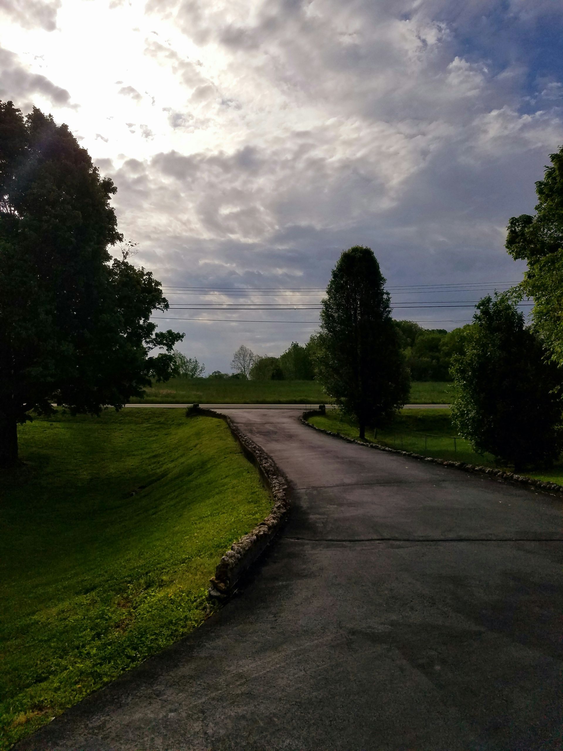 a road with grass and trees on the side